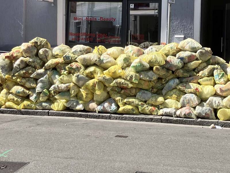 Viele gelbe Säcke liegen in einer Straße in Rheinfelden (Baden) auf einem Haufen zusammen.