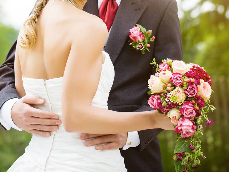 Ein Hochzeitspaar steht in einem Park