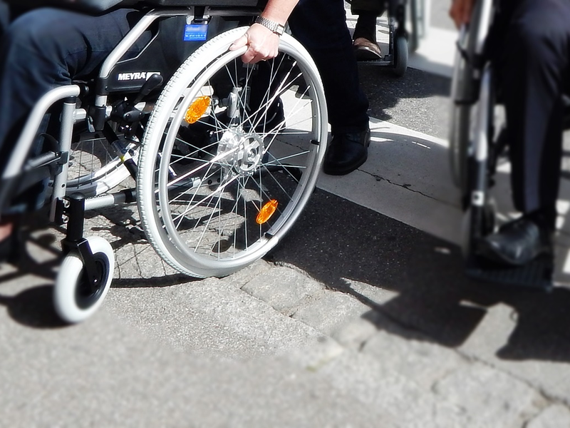 Rollstuhlfahrer an einer Bordsteinkante