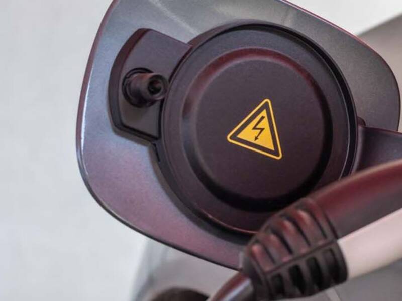 Ein Tankdeckel eines E-Cars mit Tankstecker
