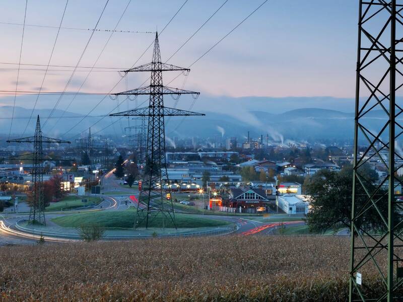 Mehrere Strommaste in einem Industriegebiet bei Nacht