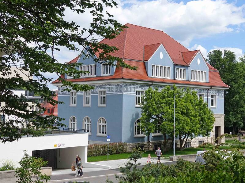 Blick auf das blaue Haus der Wohnbau vom gegenüberliegenden Salmegg-Park. 