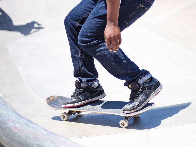 Skateboardfahrer, von dem man nur die Beine sieht, in einer Halfpipe. 