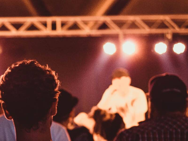 Viele Menschen schauen zu einer bühne mit Musikern