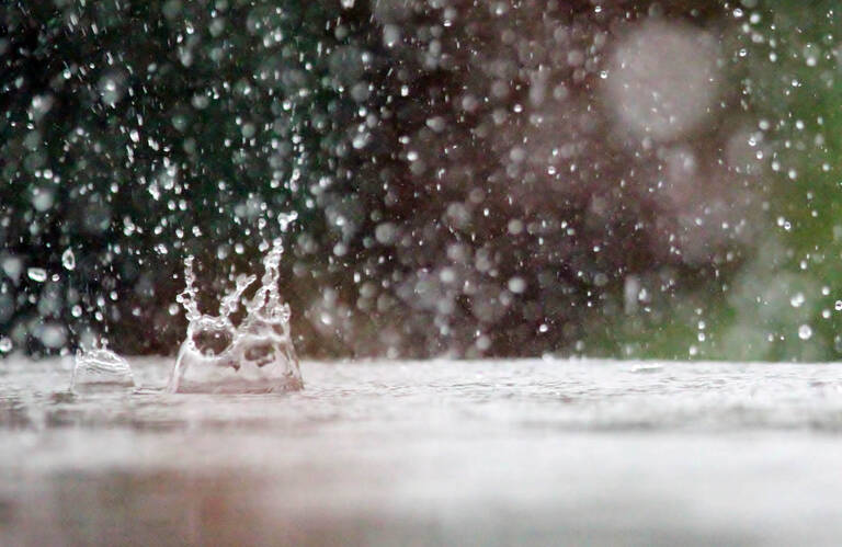 Es regnet, Wassertropfen spritzen vom Boden auf. 