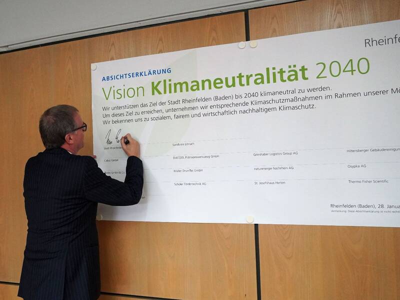 Runder Tisch Energie - Oberbürgermeister Klaus Eberhardt unterschreibt die Absichterklärung, die an der Wand hängt.