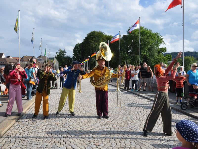 Eine Musikkapelle geht über die alte Rheinbrücke.