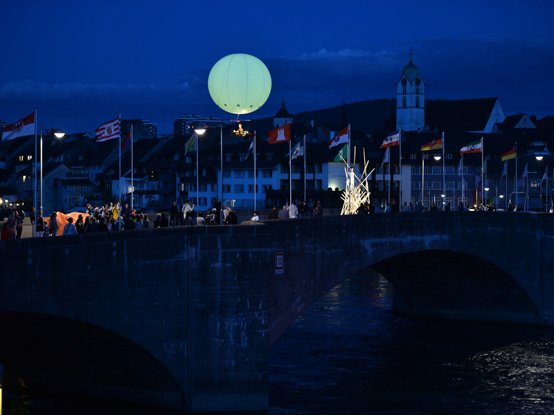 Die Rheinbrücke mit vielen Passanten bei Nacht