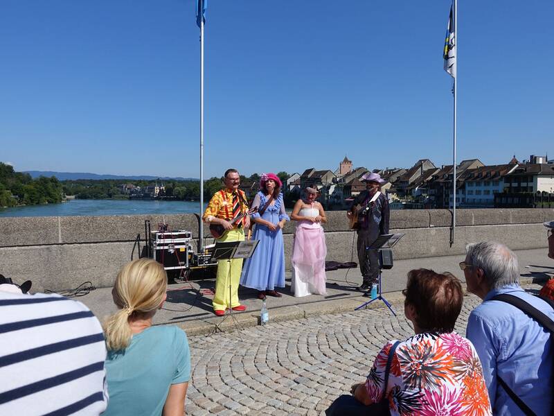Eine Musikgruppe auf der altne Rheinbrücke mit Zuschauern im Vordergrund