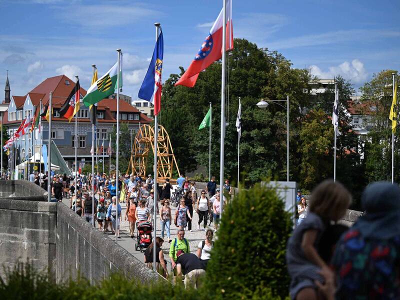 Die alte Rheinbrücke mit Fahenmasten und vielen Passanten