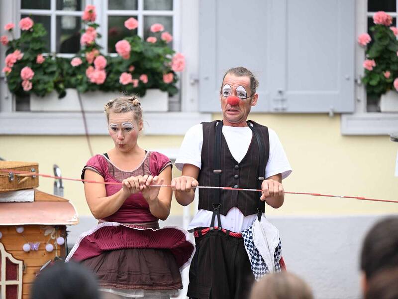 Ein Clownerie-Paar vor dem Haus Salmegg