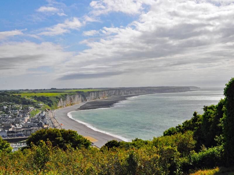 Blick von oben auf den Strand, das Meer, die Klippen und einen Teil der Stadt. 