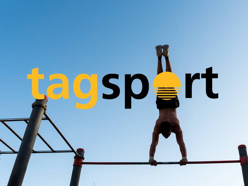 Ein Mann macht an einer Klimmzugstange einen Handstand, während im Hintergrund der Himmel zu sehen ist und der Schriftzug "tagsport" überlagert ist.