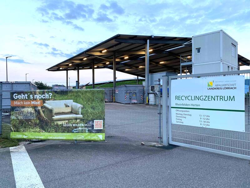 Der Recyclinghof in Herten mit Öffnungszeitenschild und Banner am Zaun