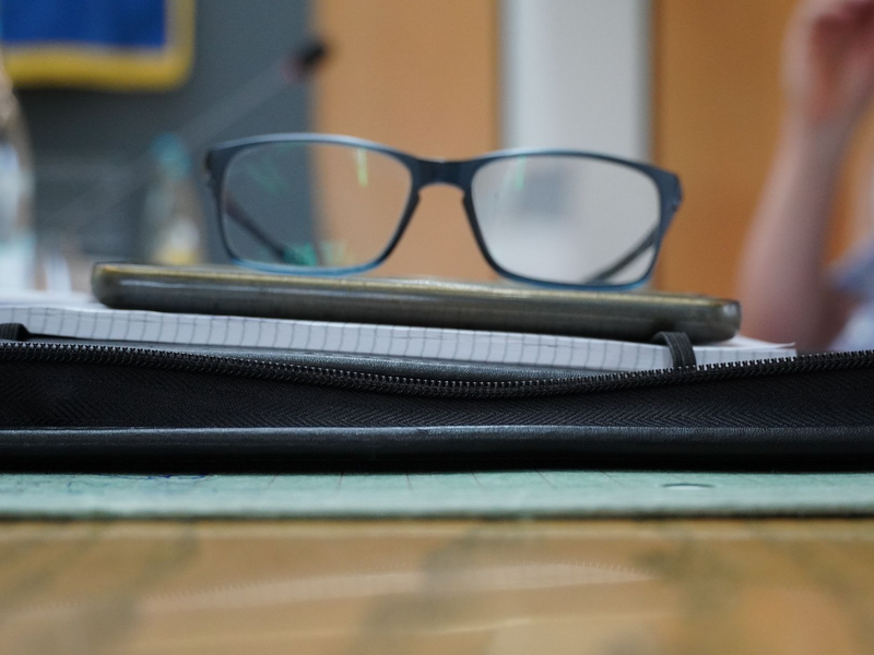 Eine Brille liegt auf einem Stapel Akten