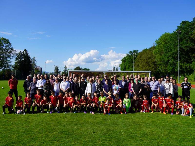 Gruppenfoto: Die Teilnehmenden des Behördentreffen stehen gemeinsam mit den Junioren des FC und FSV Rheinfelden auf dem Fußballplatz vor einem Tor. 