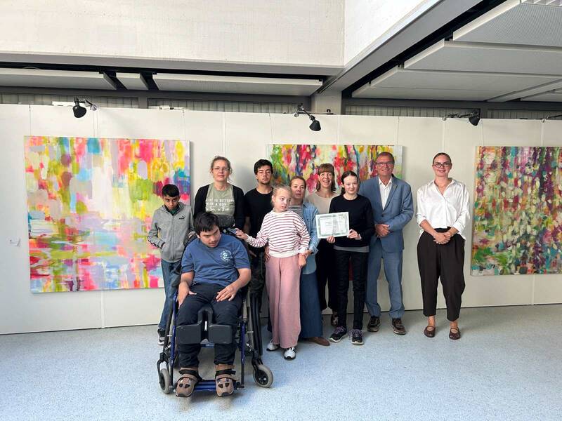 Gruppenbild: Das Redaktionsteam der Schülerzeitung Der Kreisel der Karl-Rolfus-Schule steht gemeinsam mit Betreuerinnen sowie Oberbürgermeister Klaus Eberhardt und Vanessa Hünerli von der Abteilung Schulen & Sport vor großfllächigen Bildern. 