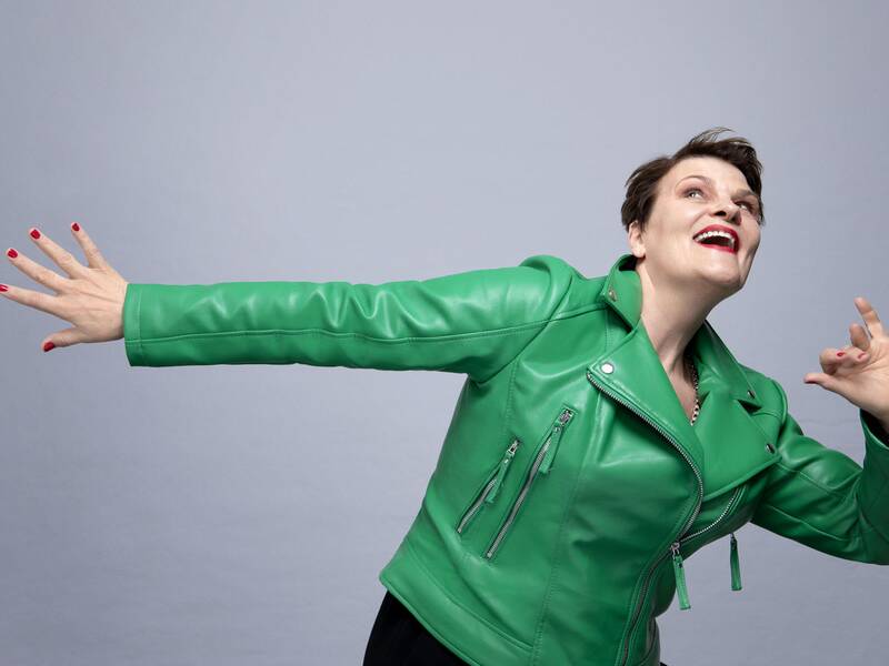 Gayle Tufts, die nach oben schaut und eine Hand nach hinten streckt.  