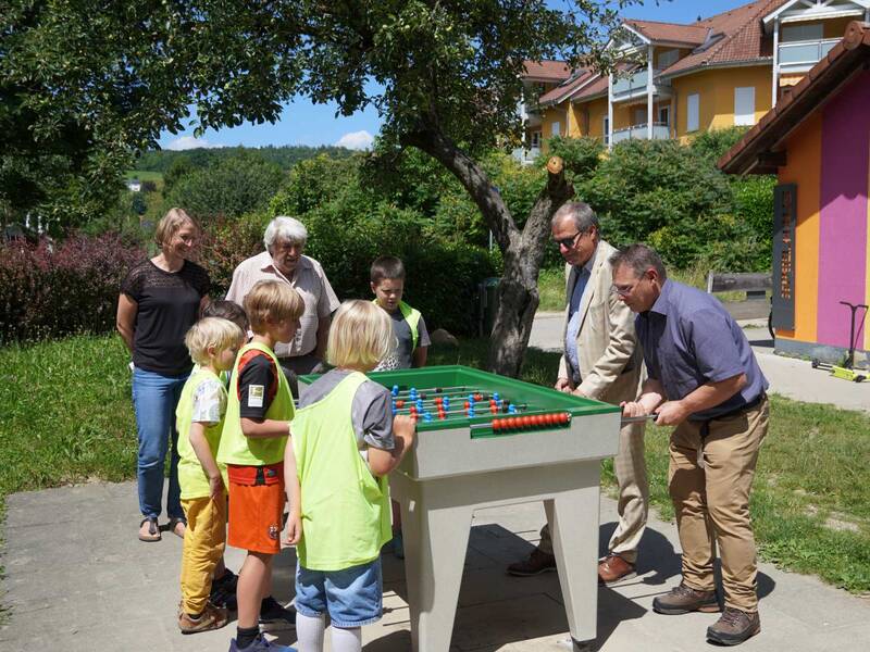 Die Freude über den neuen Outdoor-Kicker auf dem Spielplatz in Nollingen, der vom Spielhaus Nollingen gestiftet wurde, ist bei allen Beteiligten groß: Theresa Barth und Wolfgang Gorenflo (Spielhaus Nollingen) sowie Oberbürgermeister Klaus Eberhardt und Dr. Patrick Pauli (Abteilung Stadtgrün & Umwelt) freuen sich mit den Kindern der Nachmittagsbetreuung über das neue Spielgerät. 