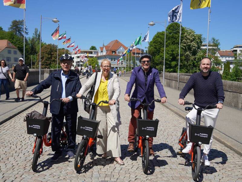Jean Frey (Gemeindepräsident Kaiseraugst), Claudia Rohrer (Stadtpräsidentin Rheinfelden), Klaus Eberhardt (Oberbürgermeister Rheinfelden (Baden)) und Markus Bacher (CEO von PubliBike) lancieren auf der Rheinbrücke das grenzüberschreitende Bike-Sharing PubliBike Hochrhein. Alle vier Personen haben PubliBike-Räder dabei.