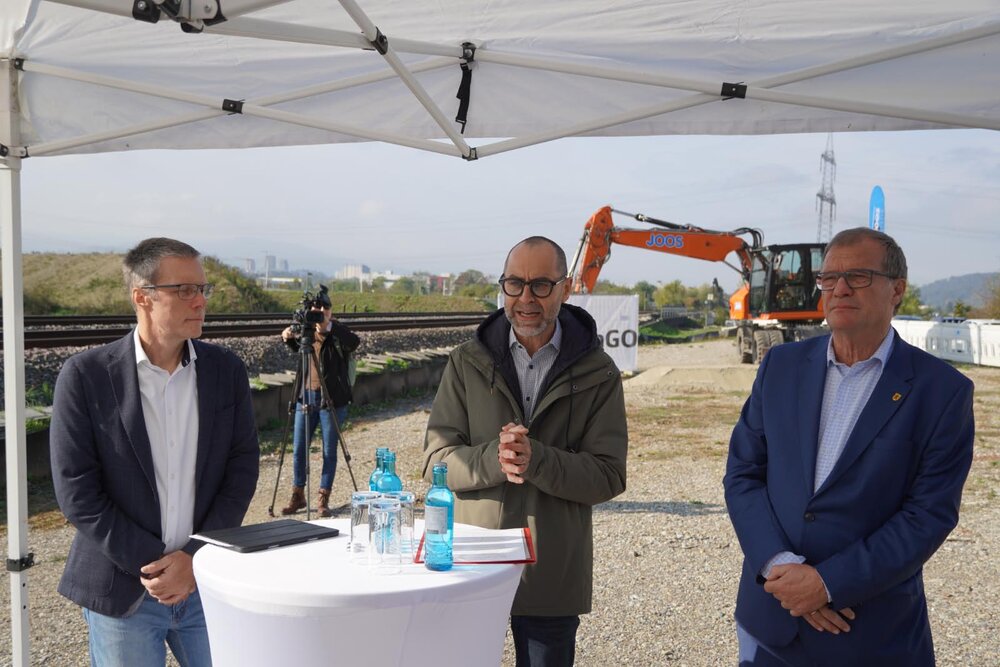 Spatenstich Haltepunkt Rheinfelden-Warmbach: (von links nach rechts) Projektleiter der DB InfraGO Christian Lösch, Ulrich Hoehler, Erster Landesbeamter des Landkreises Lörrch, und Oberbürgermeister Klaus Eberhardt loben die gute Zusammenarbeit und die Bedeutung des Prjektes. (Sie stehen an einem Stehtisch.)