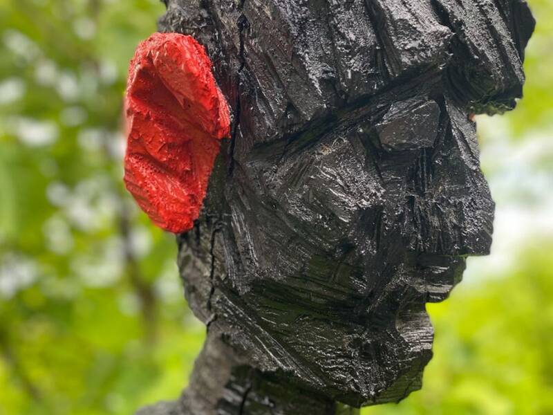 Bild von einer Bildhauerei des Künstlers Frank Faller, es stellt eine menschenartige Figur mit einem roten Ohr da